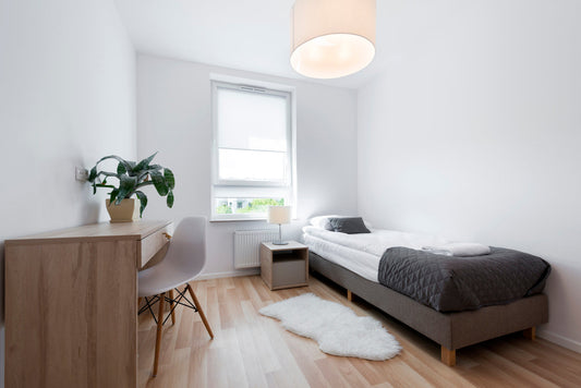 a student dorm room furnished with a bed and desk